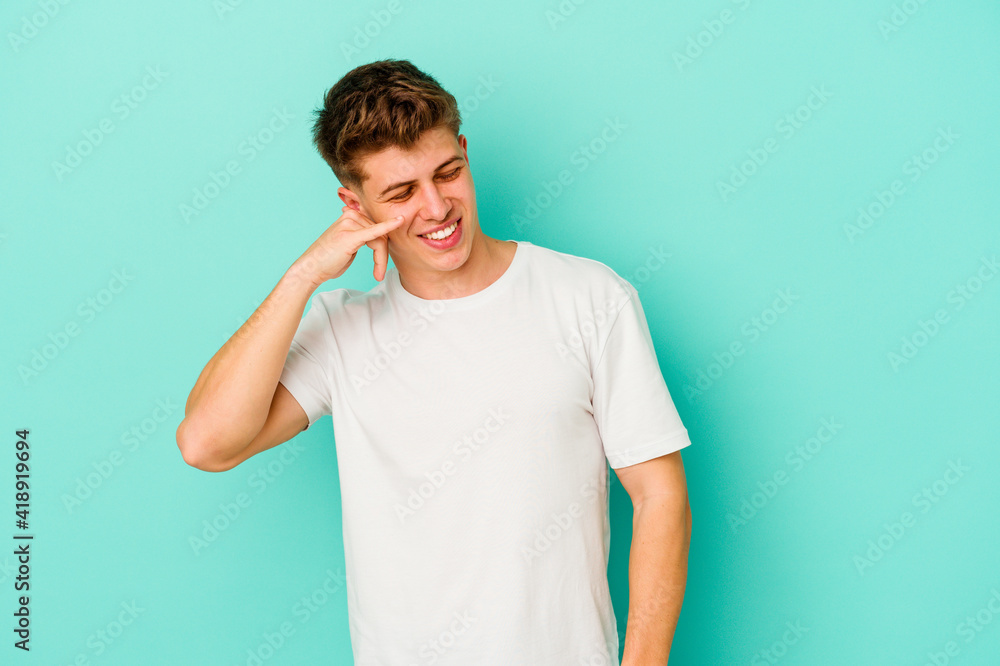 Young caucasian man isolated on blue background showing a mobile phone call gesture with fingers. Young caucasian man isolated on blue background showing a mobile phone call gesture with fingers.