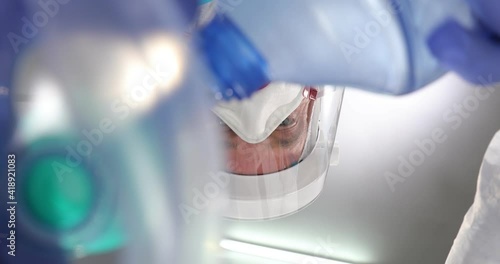 Doctors in medical clothing in covid-19 uniform with masks, putting an oxygen mask on patient to give resuscitation to a patient. Close-up. View from below on a medicals specialist. photo