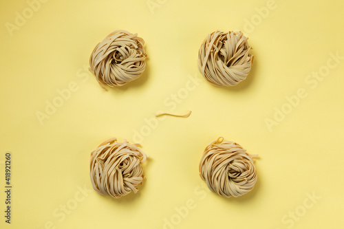 Fettuccine on yellow background. minimal composition about quality italian raw pasta. 