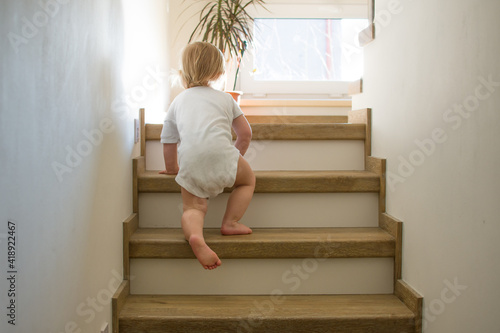Wallpaper Mural Little caucasian toddler is crawling on stairs at home in sunny interior.  Child safety at home. Danger in your house concept. Torontodigital.ca