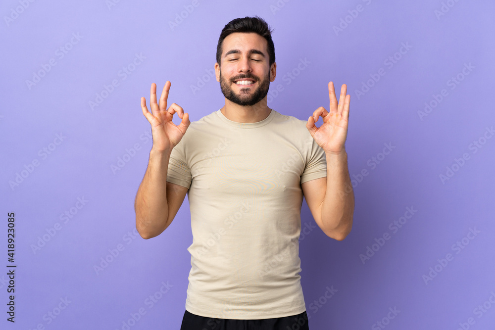 Young handsome man with beard over isolated background in zen pose - obrazy, fototapety, plakaty 
