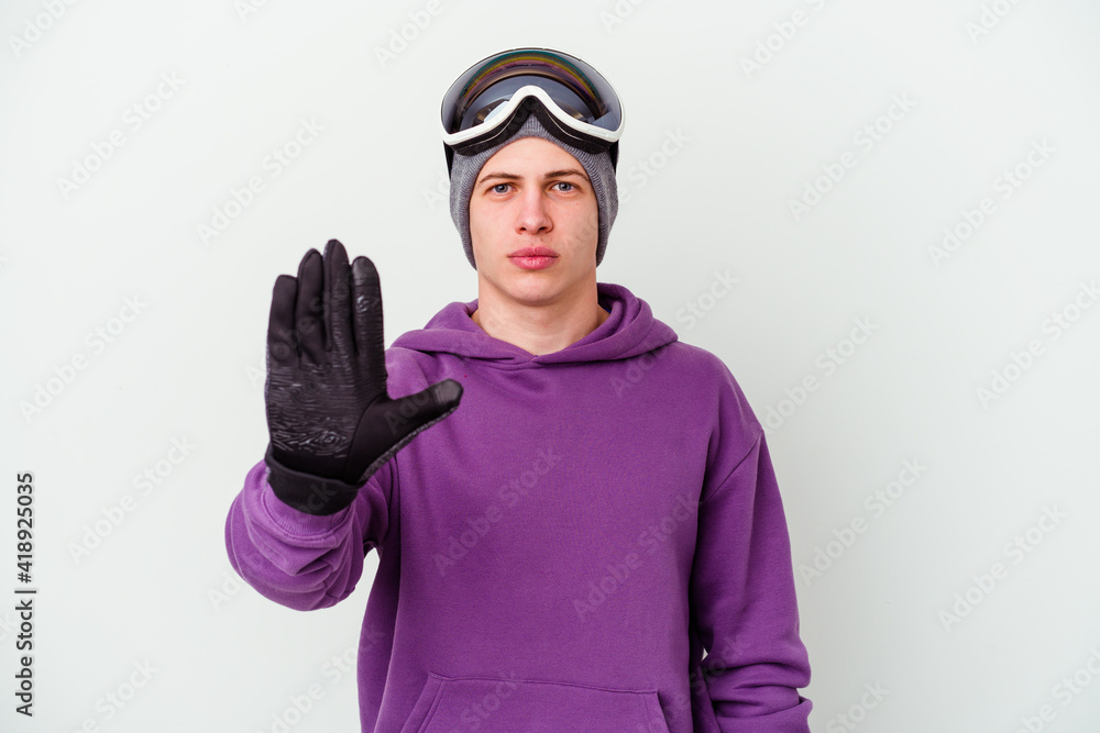 Young man holding a snowboard board isolated on white background standing with outstretched hand showing stop sign, preventing you. Young man holding a snowboard board isolated on white background standing with outstretched hand showing stop sign, preventing you.