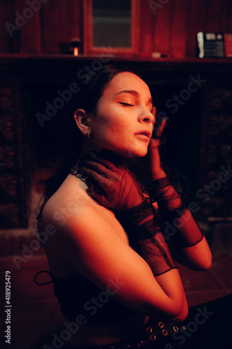 Portrait of a young sexy confident woman wearing fashionable long gloves having her eyes closed photo