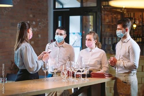 The waiters of the restaurant in a medical mask learns to distinguish between the glasses. © davit85