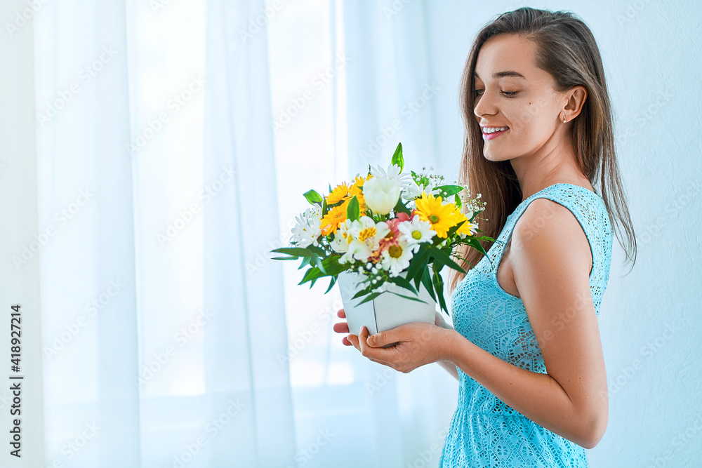 Beautiful caucasian joyful happy young smiling woman with decorative colorful bright fresh flower hat box at holiday spring women's day Beautiful caucasian joyful happy young smiling woman with decorative colorful bright fresh flower hat box at holiday spring women's day