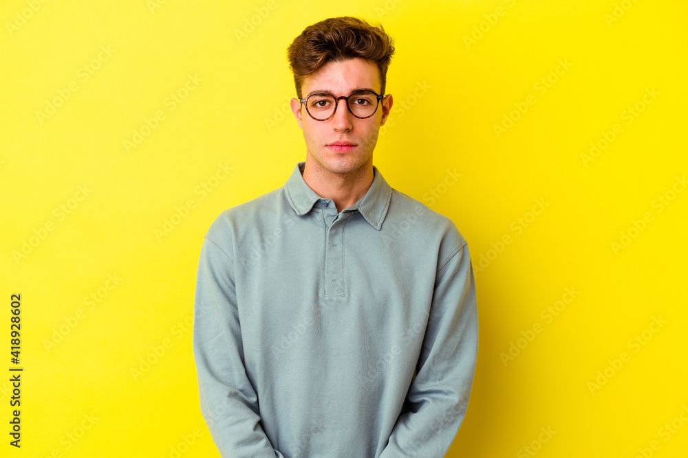 Young caucasian man isolated on yellow background sad, serious face, feeling miserable and displeased.