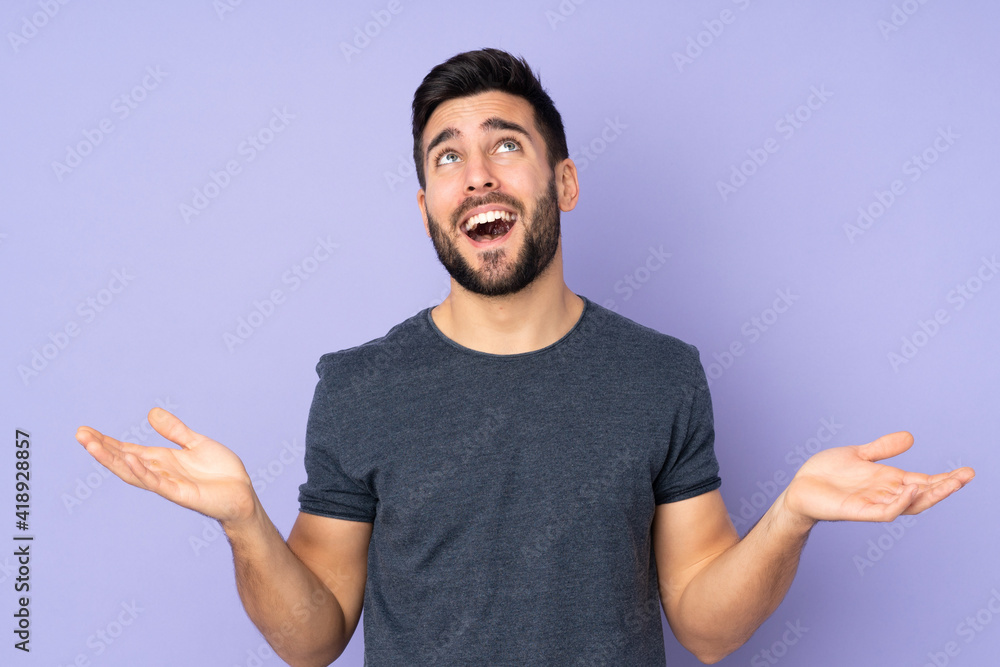 Caucasian handsome man smiling a lot over isolated purple background Caucasian handsome man smiling a lot over isolated purple background