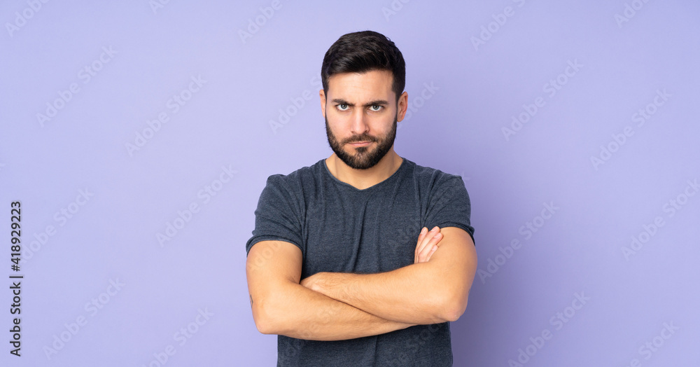 Caucasian handsome man with unhappy expression over isolated purple background Caucasian handsome man with unhappy expression over isolated purple background