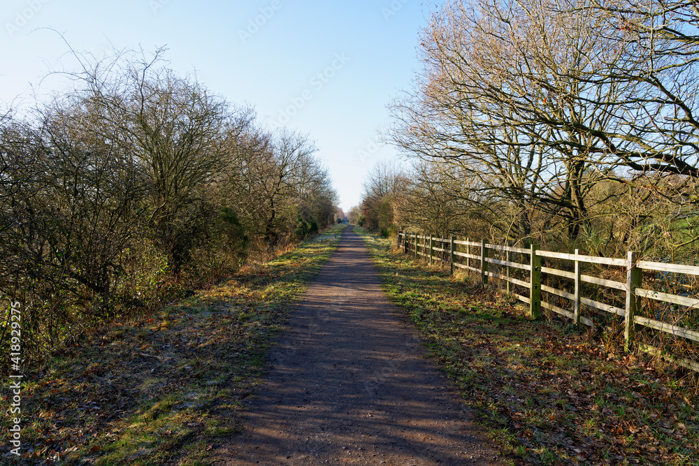 Footpath follows the route of a disused railway on a bright winter morning