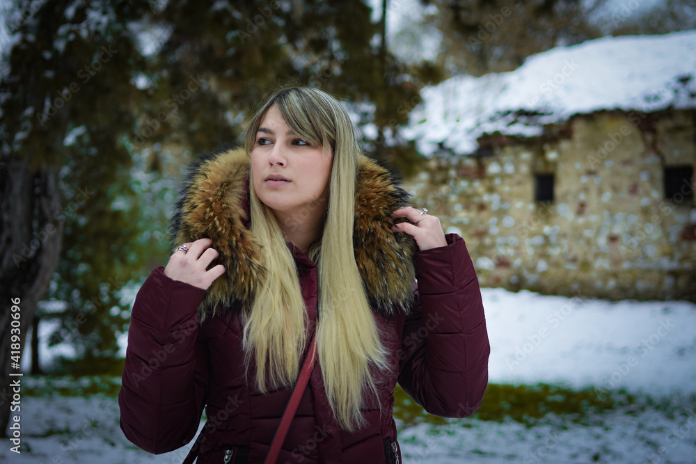 Beautiful blonde girl walking in the park on snowy winters day. Beautiful blonde girl walking in the park on snowy winters day.