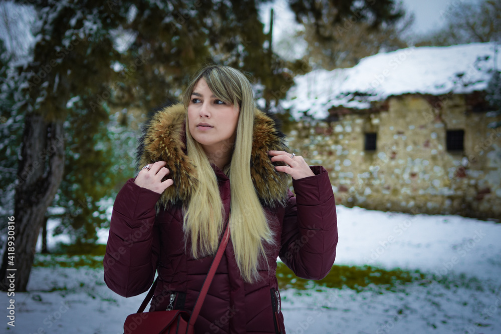 Beautiful blonde girl walking in the park on snowy winters day. Beautiful blonde girl walking in the park on snowy winters day.