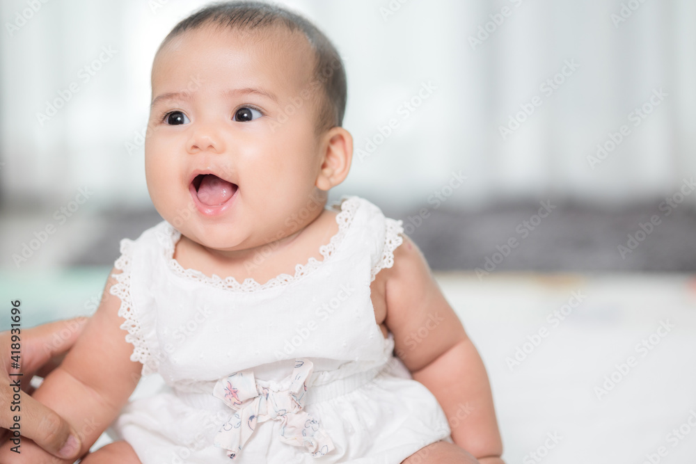 Asian baby cute sitting in the living room at home with family.