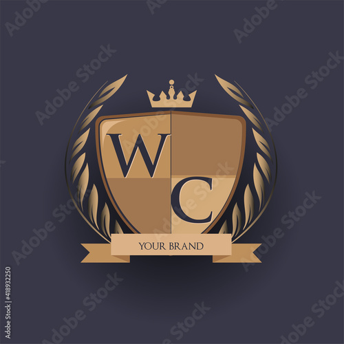 initial letter WC logotype colored brown and gold isolated with shield, crown and laurel design, logo for college and sport club.