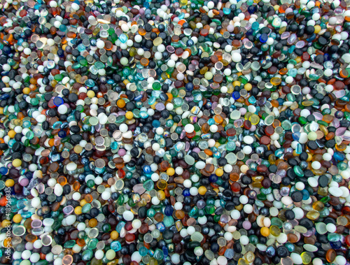 A macro photograph of thousands of colorful marbles makes a pretty background or texture and is a delight to the collector. Slight bokeh effect.