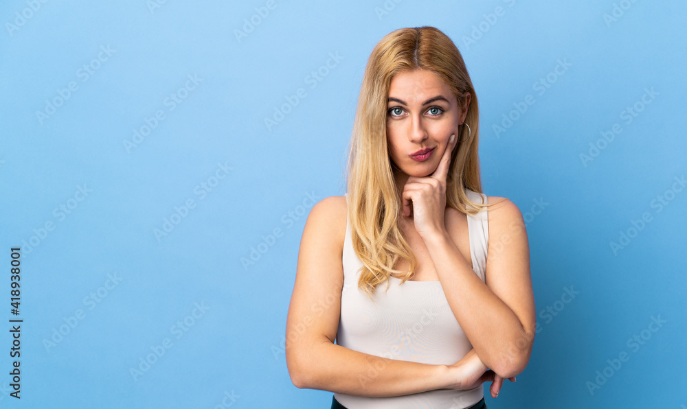 Young Uruguayan blonde woman over isolated background and thinking