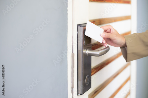 A woman's hand was holding a key card to unlock the door.