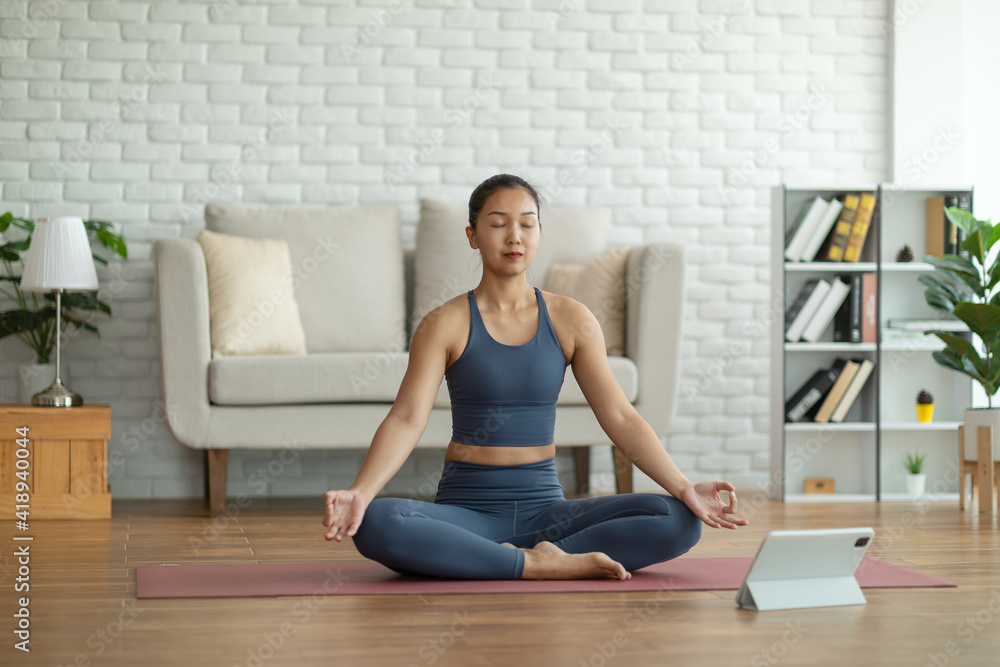 Athlete Asian indian woman looking laptop practice yoga lotus pose online course at home to meditation comfortable and relax,yoga Exercise at home Concept,Self isolation due COVID-19 pandemic Athlete Asian indian woman looking laptop practice yoga lotus pose online course at home to meditation comfortable and relax,yoga Exercise at home Concept,Self isolation due COVID-19 pandemic