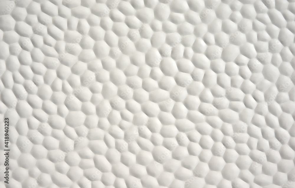 Fototapeta premium Abstrakte weiße Oberfläche einer Wand mit wabenförmigem, buckligen Muster 