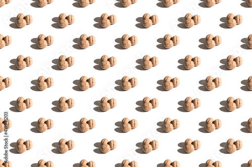 Walnuts on a white background. A pattern of walnuts on a white background. Hard shadows
