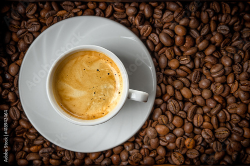 Cup of black coffee and roasted coffee beans top view