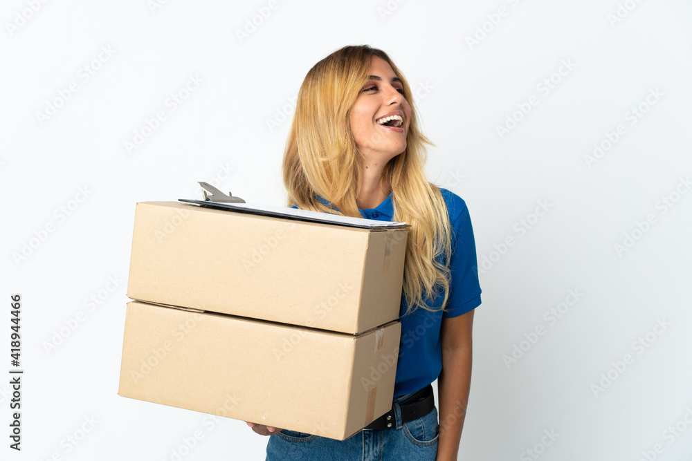 Young blonde Uruguayan delivery woman isolated on white background laughing Young blonde Uruguayan delivery woman isolated on white background laughing