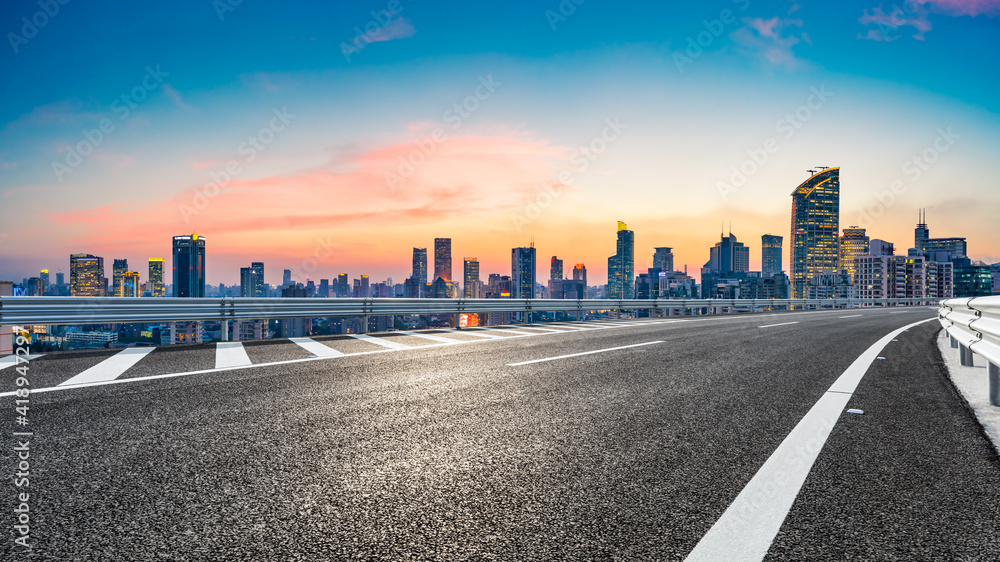 Obraz premium Empty asphalt road and city skyline with buildings at sunset in Shanghai.