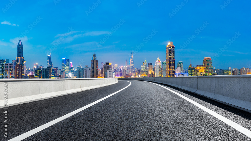 Empty asphalt road and city skyline with buildings at night in Shanghai. Empty asphalt road and city skyline with buildings at night in Shanghai.