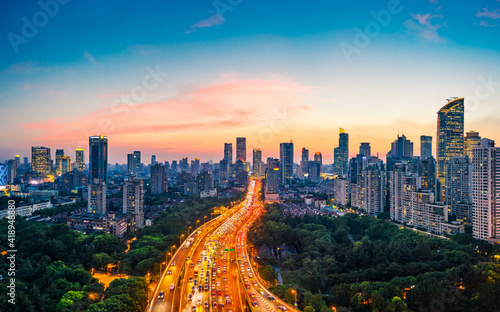 Shanghai skyline and buildings with highway at sunset.