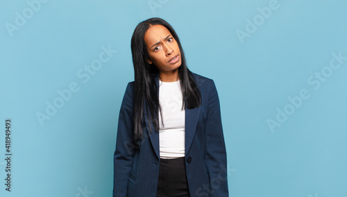 young black woman feeling puzzled and confused, with a dumb, stunned expression looking at something unexpected. business concept