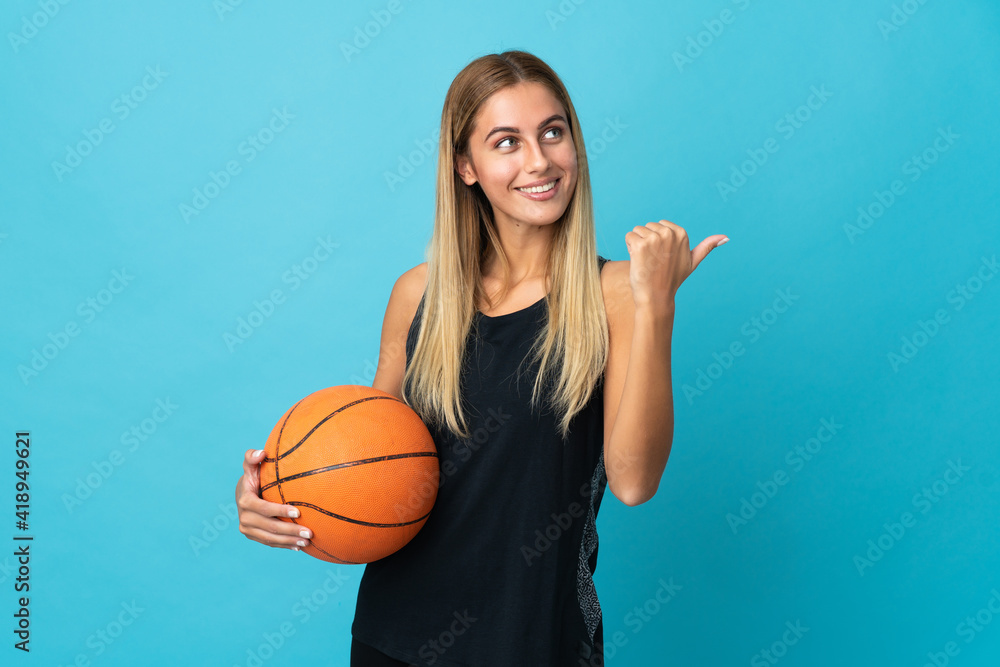 Young woman playing basketball isolated on white background pointing to the side to present a product Young woman playing basketball isolated on white background pointing to the side to present a product