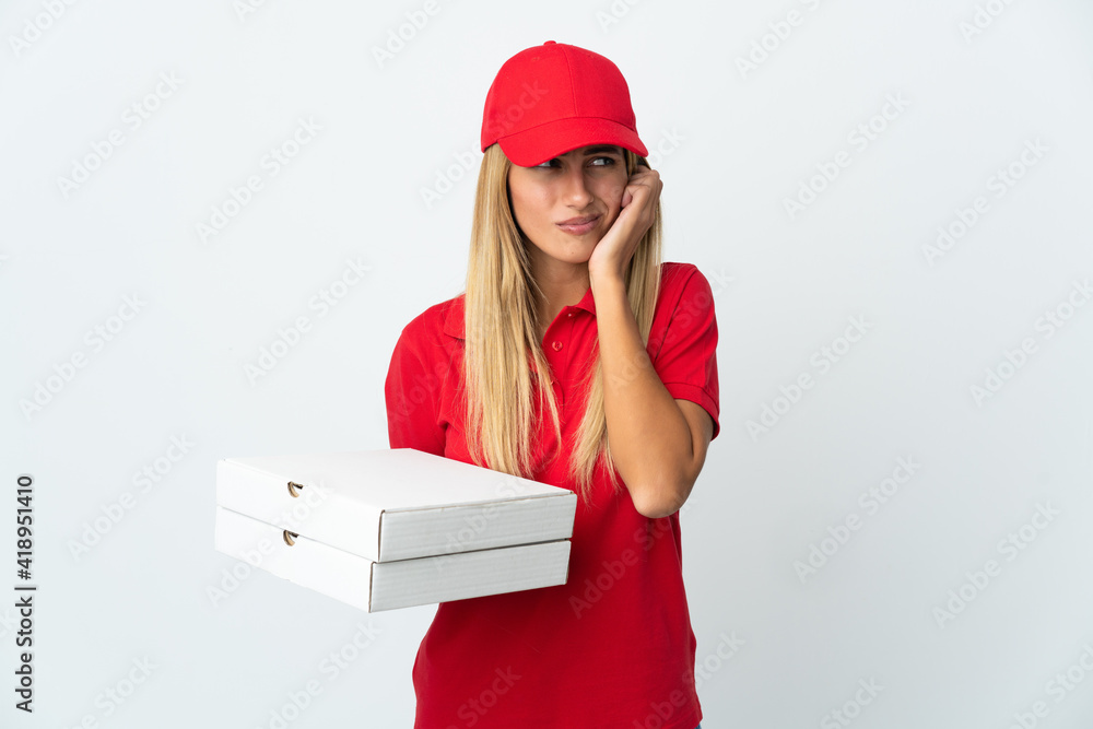 Pizza delivery woman holding a pizza isolated on white background frustrated and covering ears Pizza delivery woman holding a pizza isolated on white background frustrated and covering ears