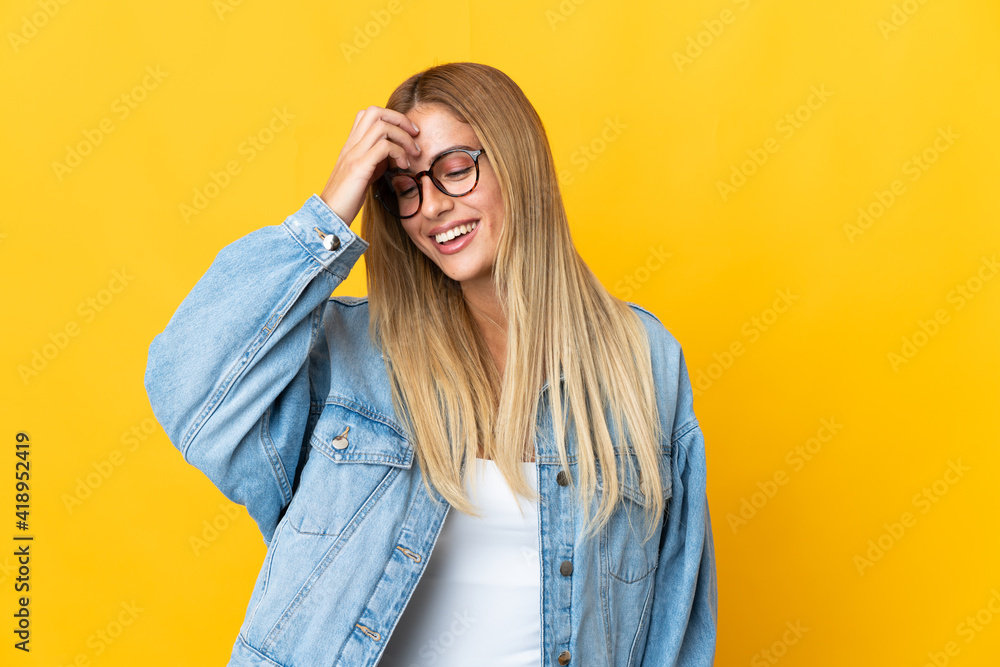 Young blonde woman isolated on yellow background laughing Young blonde woman isolated on yellow background laughing