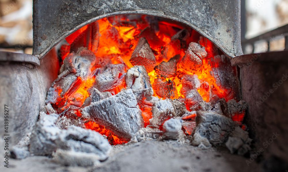 Burning coals in a metal grill for frying meat and vegetables. Burning coals in a metal grill for frying meat and vegetables.