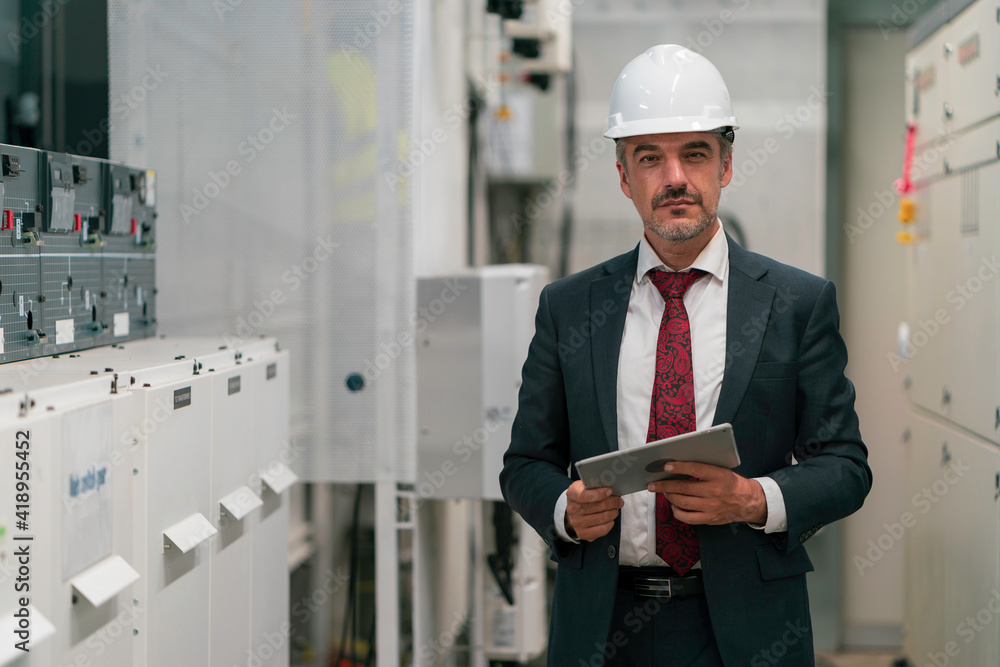 Portrait shot of senior engineer or management inspecting work in the electrical control room Portrait shot of senior engineer or management inspecting work in the electrical control room
