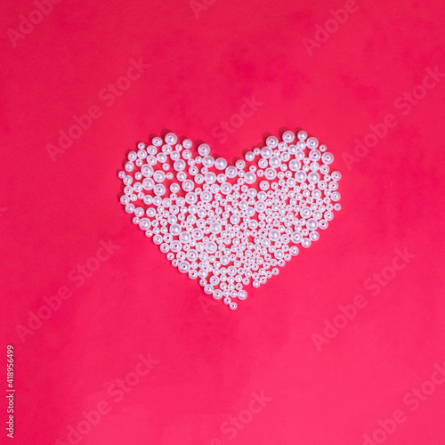 pearl heart on a red background, a creative concept for Valentine’s Day and Mother’s Day