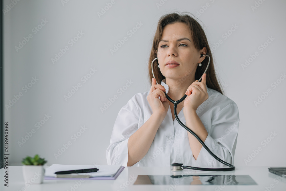 Smiling female physician posing in hospital office. Medicine concept