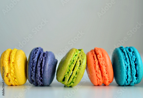 Multicolored macaroons on white background, close up