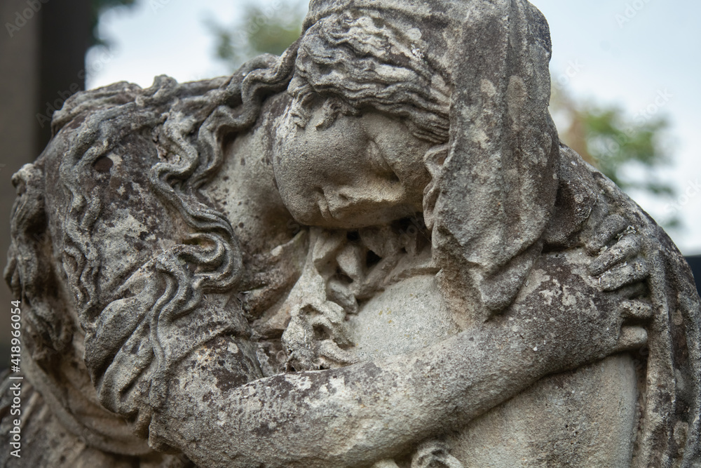Fragment of an ancient stone statue of sad and desperate woman on tomb as a symbol of death and the end of human life. Close up. Horizontal image.