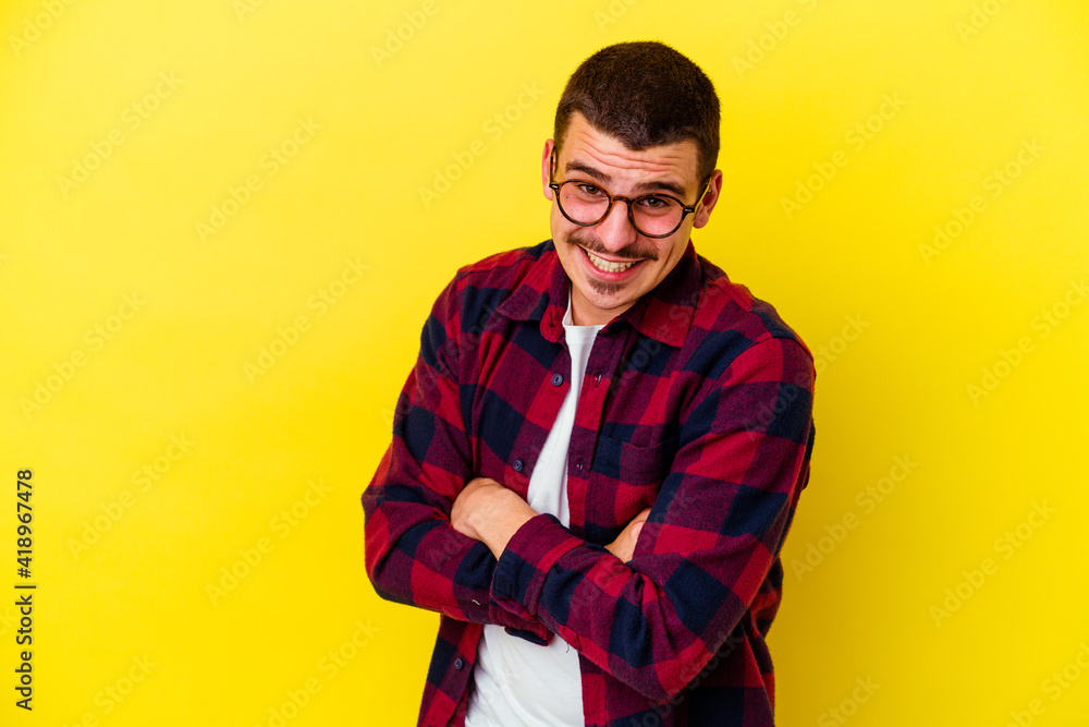 Fototapeta premium Young caucasian cool man isolated on yellow background laughing and having fun.