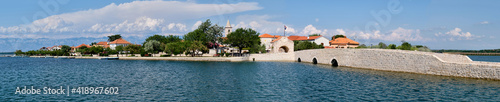 Panoramic image of Nin, historic medieval town in the Zadar County of Croatia. Panoramic banner image of bridge that leads to city center in a lagoon on the Adriatic Sea.