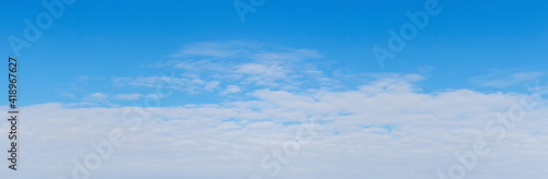 White dense clouds on a blue sky, panorama