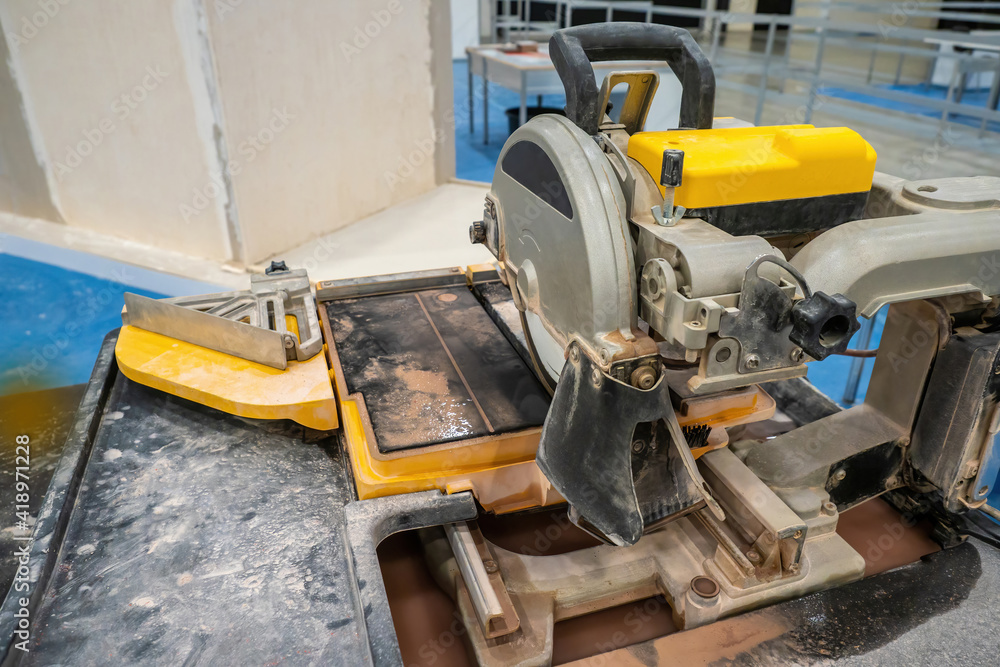 Circular saw for cutting stone. Stationary circular saw. Stone and tile processing. Tile cutting process. Concept - sale of construction equipment. Rental of construction devise. Circular saw for cutting stone. Stationary circular saw. Stone and tile processing. Tile cutting process. Concept - sale of construction equipment. Rental of construction devise.