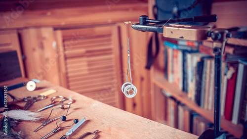 Foto Fishing fly tying materials and tools on a wooden table