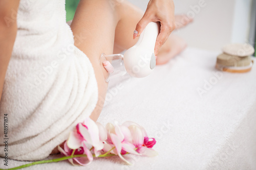Woman getting LPG massage for skin care in home