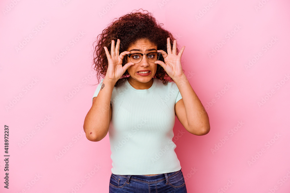Young african american woman isolated on pink background keeping eyes opened to find a success opportunity. Young african american woman isolated on pink background keeping eyes opened to find a success opportunity.