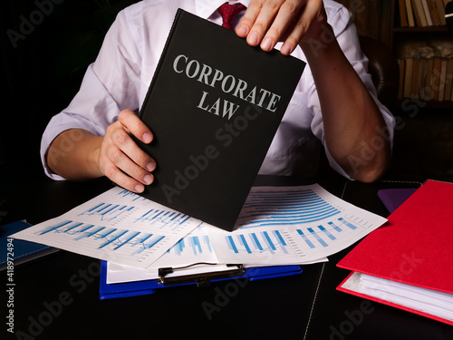 Man propose corporate law book in the office.