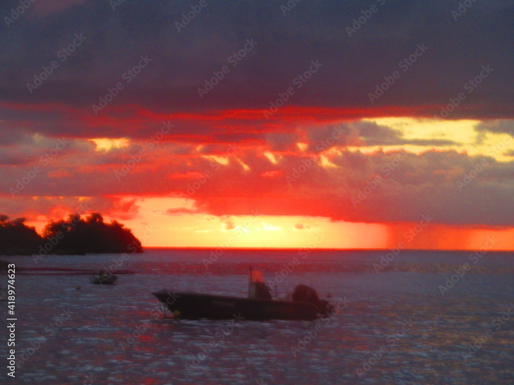 Le soleil se couche sur la mer derrière les bateaux