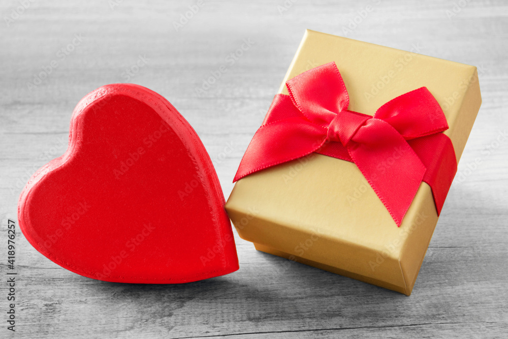 Red heart and golden gift box close up Red heart and golden gift box close up