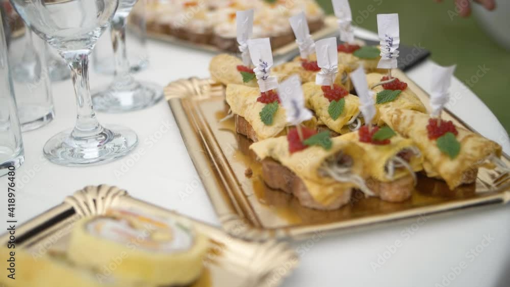 Detail of catering snack served at a table in a outdoor´s event, detail in slow moition Detail of catering snack served at a table in a outdoor´s event, detail in slow moition