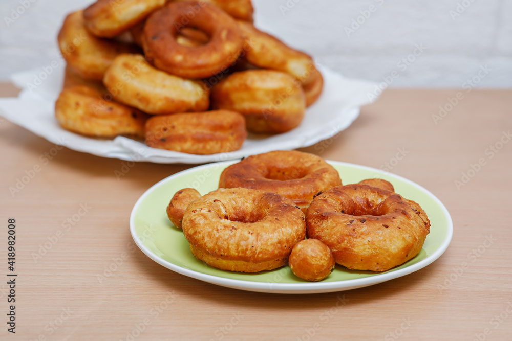 Traditional pastries. Homemade donuts. Photo 6: finished fried donuts are stacked on a plate. Traditional pastries. Homemade donuts. Photo 6: finished fried donuts are stacked on a plate.